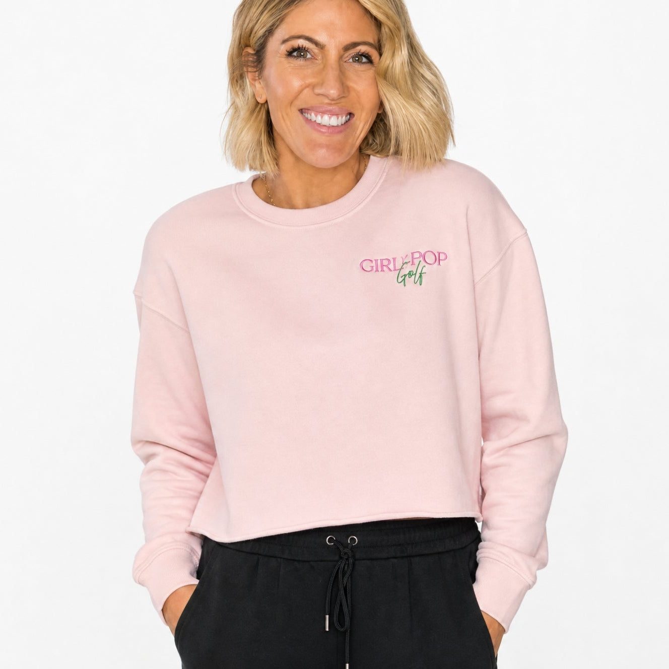 Pale pink cropped sweatshirt with an embroidered logo on the chest.