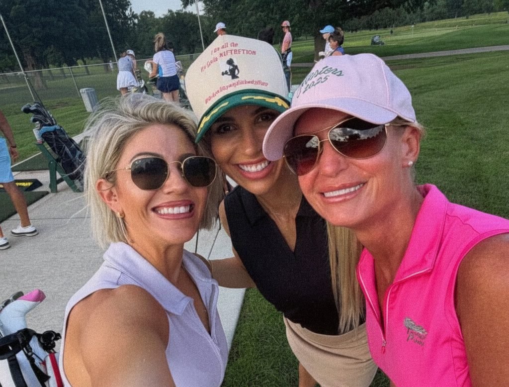 Three Girly Pop members in caps and sunglasses beside the carts at a range night.